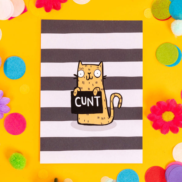 A6 Naughty Sweary Postcard Black and White striped background featuring a smiley yellow illustrated cat holding a black sign that reads 'Cunt'. Designed by Katie Abey in the UK