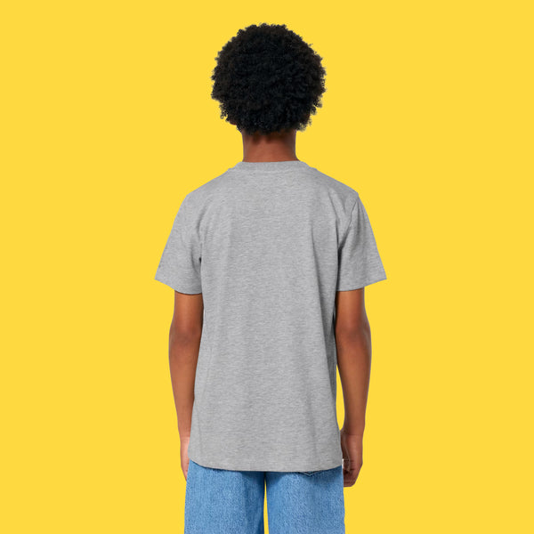 Back view of a child wearing the Cute But Feral Cat Kids T Shirt by Katie Abey in heather grey. Short sleeve organic cotton tee with a comfy unisex fit and plain back, shown against a bright yellow studio background.