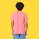 Back view of a child wearing the Cute But Feral Cat Kids T Shirt by Katie Abey in pink joy. The short sleeve organic cotton tee has a relaxed fit and plain back, shown on a model against a bright yellow studio background.