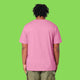 Back view of a model wearing the pink Embrace Your Weirdness adults t shirt. The plain pink back and short sleeves highlight the comfortable unisex fit and soft fabric.