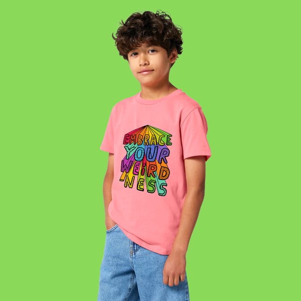Child wearing Embrace Your Weirdness kids t shirt by Katie Abey in pink joy. Bright rainbow artwork on the front celebrating individuality and creativity. Soft organic cotton tee perfect for confident weird kids.