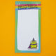 Detail of Katie Abey frog pad showing green wizard frog illustration with purple cape and starry hat. Humorous notepad design, ideal gift for stationery lovers, list makers, or anyone who enjoys playful motivational office supplies.