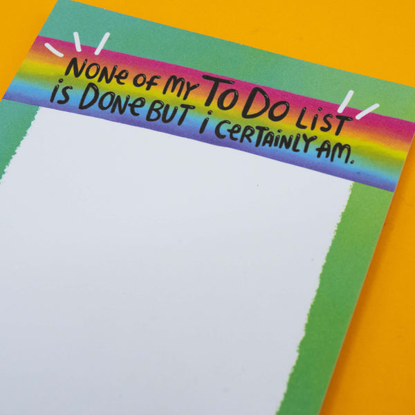 Close-up of Katie Abey’s quirky frog notepad with the phrase “None Of My To Do List Is Done But I Certainly Am” on a rainbow header. Fun stationery gift for list lovers and fans of weird, motivational desk accessories.