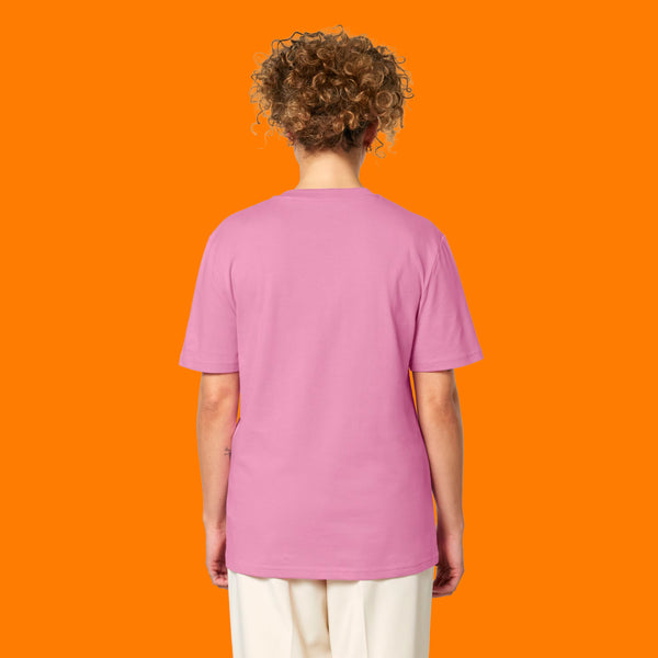 Back view of a model wearing the Katie Abey Grateful To Be Here But Respectfully WTF adults t shirt in bubble pink. Unisex organic cotton tee with short sleeves and a relaxed fit, featuring a plain back and styled against a bright orange studio background.
