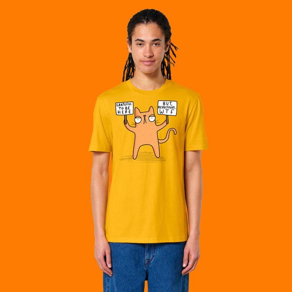 Front view of a model wearing the Katie Abey Grateful To Be Here But Respectfully WTF spectra yellow graphic t shirt. Features Katie Abey’s humorous cartoon cat illustration with relatable slogan signs. Alternative unisex tee styled with jeans.