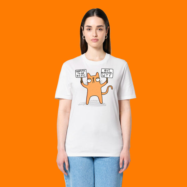 Front view of a model wearing the Katie Abey Grateful To Be Here But Respectfully WTF white graphic t shirt. Features a funny cartoon cat illustration holding humorous protest signs. Unisex alternative tee designed by illustrator Katie Abey.