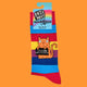 A close-up of rainbow-striped socks with packaging from Katie Abey, showcasing an orange cat holding a bold sign that reads, "I F***ing Hate People." Vibrant and unapologetically fun, these socks celebrate weirdness and individuality.