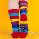 Back view of the “I F*cking Hate People” socks. The Katie Abey and Soctopus logos are displayed on the heel with rainbow stripes. A quirky touch for sock lovers.