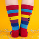 Close-up view of the sock design, showing the orange cat graphic and bold lettering. The colourful rainbow pattern adds a fun twist.