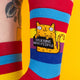 Close-up view of the sock design, showing the orange cat graphic and bold lettering. The colourful rainbow pattern adds a fun twist.