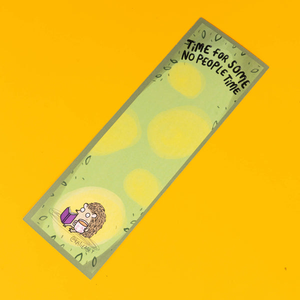 Katie Abey bookmark featuring a small, cartoon hedgehog sitting contentedly, reading a purple book. The bookmark has a soft green background with light yellow spots, and at the top, the phrase 'Time For Some No People Time' is written in playful black lettering. The design is surrounded by a subtle leafy border, perfectly capturing a peaceful, introverted moment