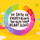 In spite of everything you kept your heart kind vinyl sticker, rainbow background with black writing and white stars. Designed by Katie Abey in the UK