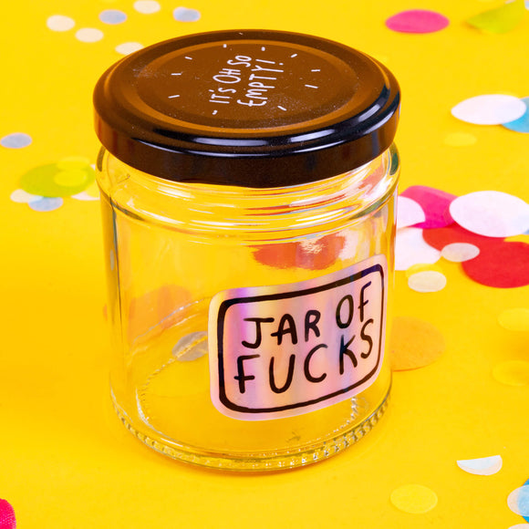 Jar of Fucks clear empty glass with shiny vinyl sticker and black lid with white writing reads 'It's oh so empty!' Designed by Katie Abey in the UK