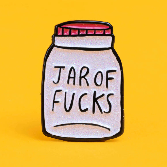 Katie Abey soft enamel pin featuring a whimsical design of a jar labelled 'Jar of Fucks' with text above it saying 'It's Oh So Empty' and text below it saying 'Literally Nothing'. The pin is sat against a yellow backdrop.