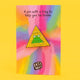 Katie Abey 'Leap of Faith' frog pin on a colourful rainbow background card. The green frog on the pin sits on a yellow glittery triangle with the words 'Taking a Leap of Faith'. Text above reads, 'A pin with a frog to help you be brave'.