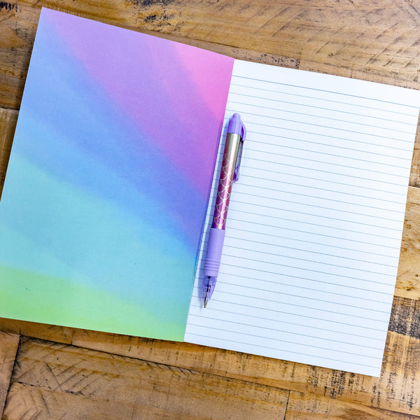 A notebook with a washed tie dye multicoloured vibe with an illustration by Katie Abey of a lined piece of paper on the front and Life Plan - Keep following whatever makes my soul sparkle the most on the front.