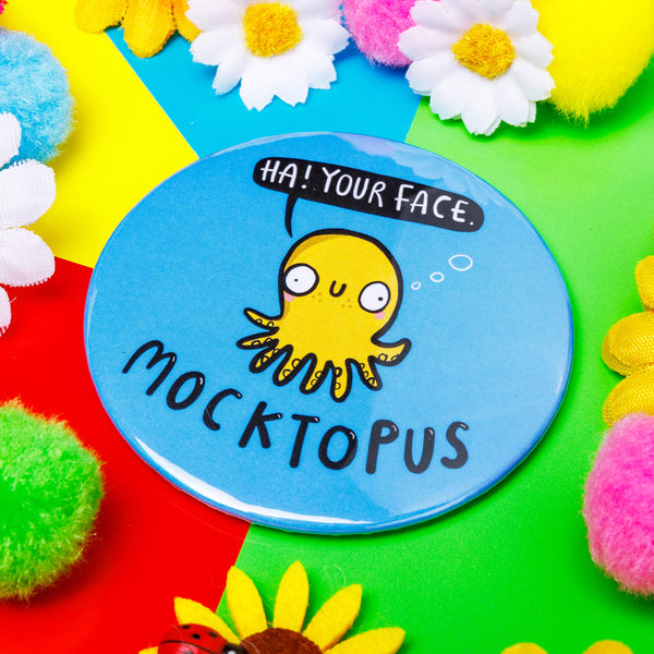 Mocktopus The Octopus circular pocket mirror, featuring a yellow octopus with a smiley face and a black speech bubble which reads 'Ha! Your Face'