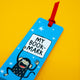Close-up of Katie Abey My Bookmark Monkey bookmark featuring a cute cartoon monkey holding a sign that reads “My Bookmark”. Blue background with white stars and red ribbon. Fun, quirky reading accessory gift.