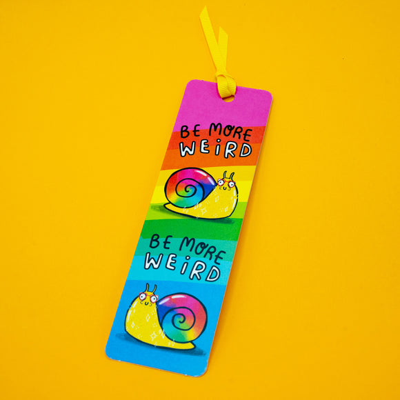 Full view of Katie Abey Be More Weird Snail Bookmark on yellow background, featuring two colourful rainbow snail illustrations and repeated “Be More Weird” slogan. Finished with a yellow ribbon, perfect for book lovers and unique gifts.