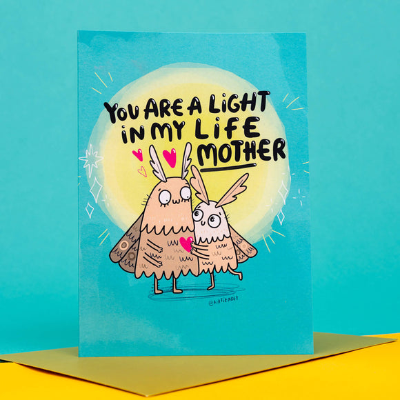 funny A6 Mother's Day card with mum moth and baby moth illustrations designed by Katie Abey on a teal card with a yellow light behind the moths. Card comes with gold envelope