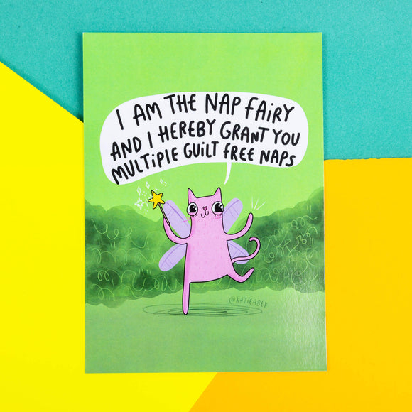 A green postcard of a cat with fairy wings and wand saying, I am the nap fairy and I hereby grant you multiple guilt free naps. 