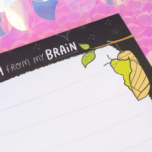 Close-up of a green caterpillar transforming into a chrysalis on a notepad by Katie Abey. Text reads “Mush from my Brain.” Ideal for inspiring creativity and transformation through mindful journaling.