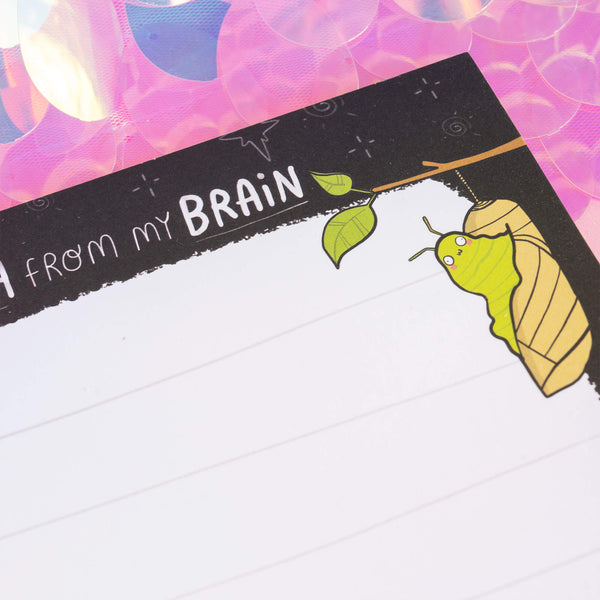 Close-up of a green caterpillar transforming into a chrysalis on a notepad by Katie Abey. Text reads “Mush from my Brain.” Ideal for inspiring creativity and transformation through mindful journaling.