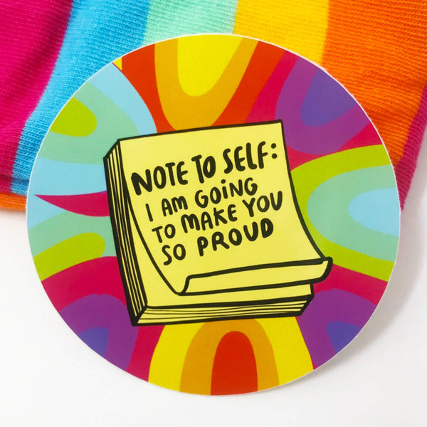 Circular sticker with rainbow pattern and featuring a yellow pile of post it notes which read 'Note to self: I am going to make you so proud' in black writing. Designed in the UK by Katie Abey