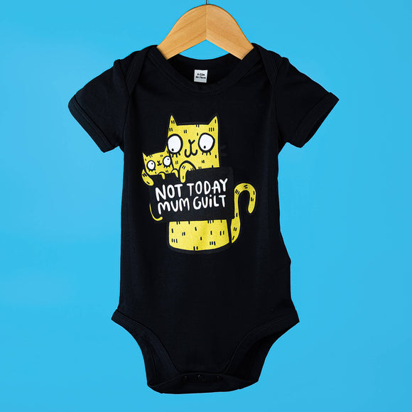 Black baby grow for babies featuring a yellow illustrated cat holding sign that reads 'Not Today Mum Guilt'. Designed by Katie Abey in the UK
