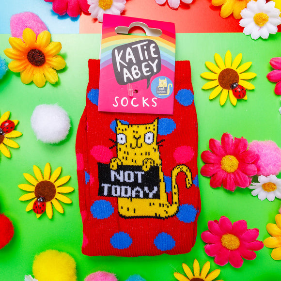 Not Today Knitted Red Kids Socks with blue and pink polka dots and yellow smiley cat holding sign. Designed by Katie Abey in the UK