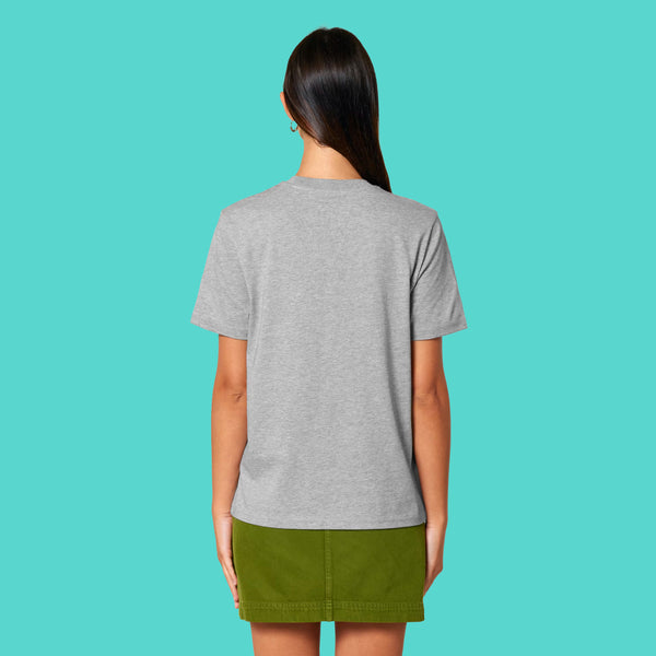 Back view of a model wearing the Sweary Cat Off You F*ck Adults Tee by Katie Abey in heather grey. Unisex T shirt with a relaxed fit and plain back, styled casually on a turquoise background. Designed by a UK illustrator who celebrates being weird and unapologetic.