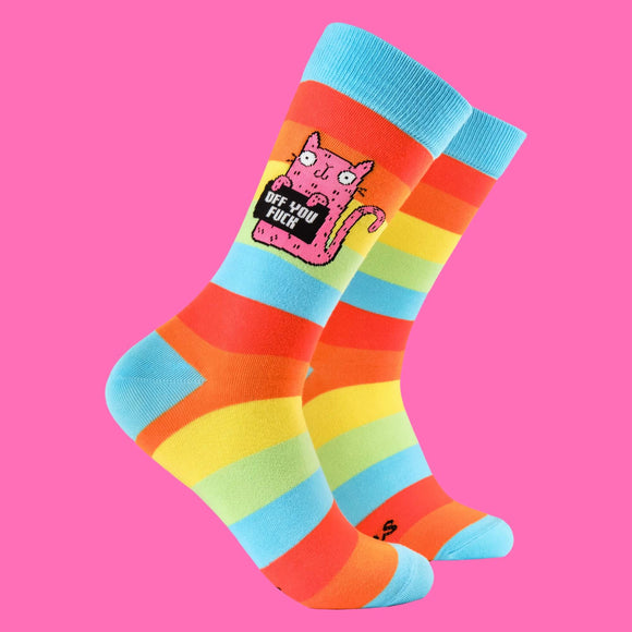 Bright rainbow striped socks featuring a quirky pink cat illustration holding a sign that says "Off You F***". Designed by Katie Abey, an illustrator who encourages embracing weirdness. Fun, bold, and perfect for adding a pop of colour to any outfit.