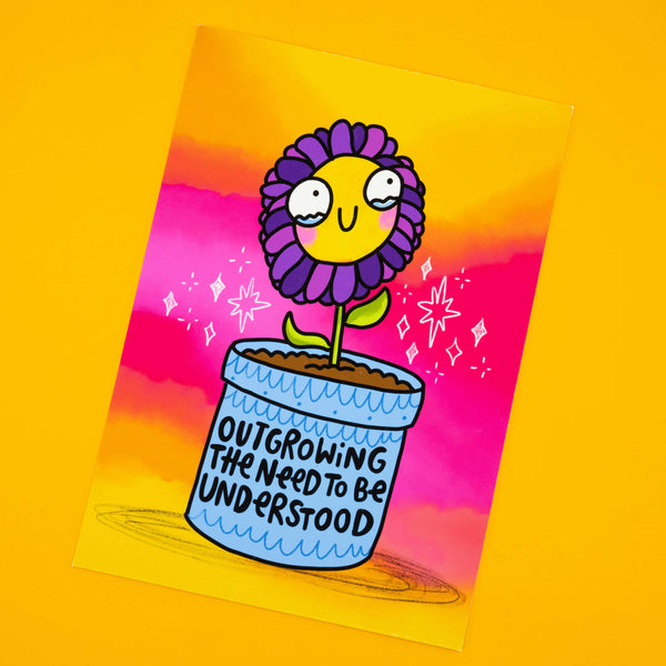 Katie Abey illustration print titled Outgrowing The Need To Be Understood. Features a cheerful purple flower in a pot on a vibrant pink and orange background. A4 matte finish limited edition wall art, signed and numbered by the artist.