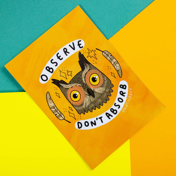 An orange postcard with an illustration of an owl with feathers and sparkles around their head with observe and don't absorb written around it.