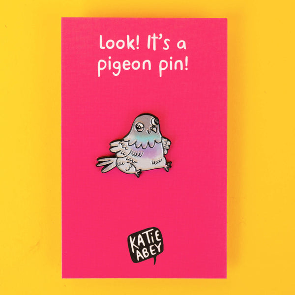 Katie Abey pigeon enamel pin on bright pink backing card that reads, "Look! It's a pigeon pin!" A fun, pastel-coloured pin that encourages embracing your weirdness while supporting a small business. A great gift for pin enthusiasts or quirky friends.