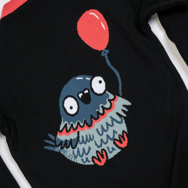 Close up of the Katie Abey x Rebel Romance Pigeon Party Long Cardigan showing the large pigeon holding a red balloon knitted into the back. Black longline cardigan with bright red trim and detailed pigeon illustration in soft acrylic knit.

