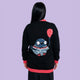 Back view of Katie Abey x Rebel Romance Pigeon Party Long Cardigan showing large pigeon holding a red balloon. Black longline knit with red hem and cuffs. Quirky illustrated bird design by Katie Abey.
