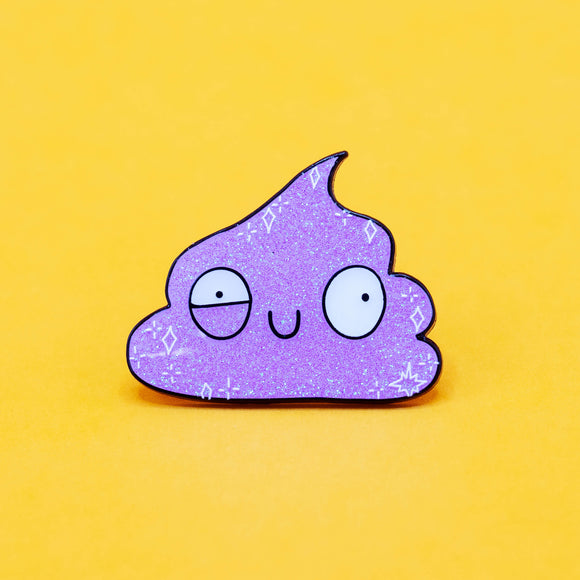 Isolated image of the Galactic Poo Glitter Enamel Pin Badge by Katie Abey. The soft enamel pin features a glittery purple poo with a silly face, black outline, and is photographed against a yellow background.
