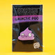Photo of Katie Abey’s Galactic Poo Glitter Enamel Pin Badge in packaging, with a motivational message above the pin and a bold “Galactic Poo” title. The purple glitter poo character has a goofy, spaced-out expression and is displayed on a black backing card.