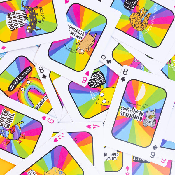 The pack of positivity cards all messy and in different orientations. The cards are fun and have rainbows and Katie Abey characters illustrated on them. 