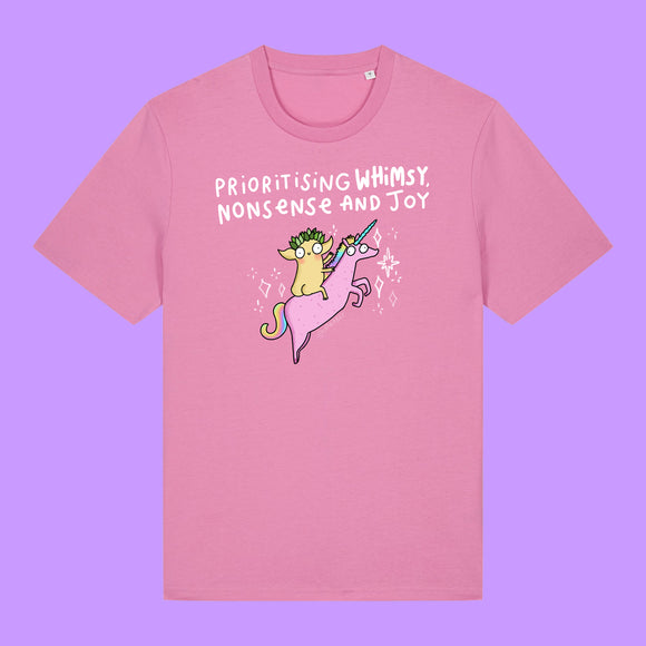 Front view of a Bubble Pink Katie Abey Prioritising Whimsy, Nonsense and Joy adults graphic t-shirt. Features a colourful illustration of a quirky character riding a pink unicorn with playful lettering celebrating whimsy and joy.
