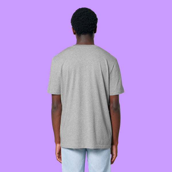 Back view of a heather grey Katie Abey Prioritising Whimsy, Nonsense and Joy adults tee worn by a model. The unisex organic cotton t-shirt shows the plain back and relaxed everyday fit against a purple background.