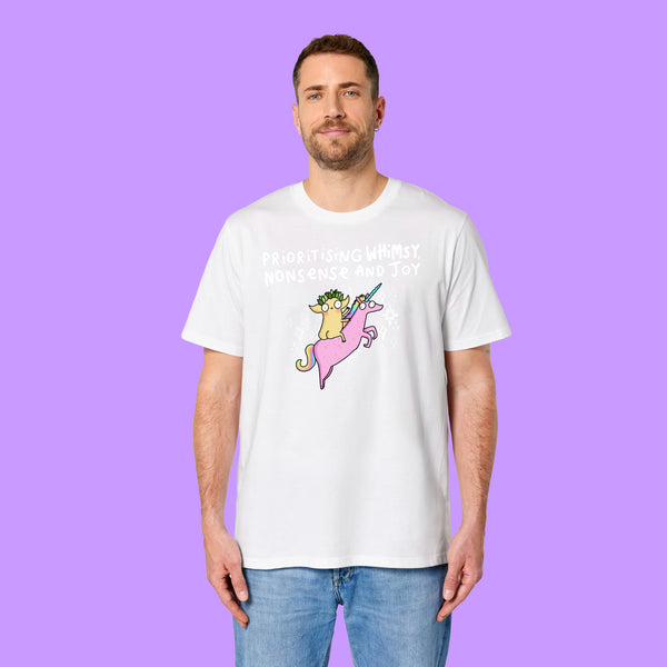 Front view of a white Katie Abey Prioritising Whimsy, Nonsense and Joy adults graphic tee worn by a model. The organic cotton unisex t-shirt features colourful unicorn artwork and fun lettering celebrating joy, whimsy and nonsense.