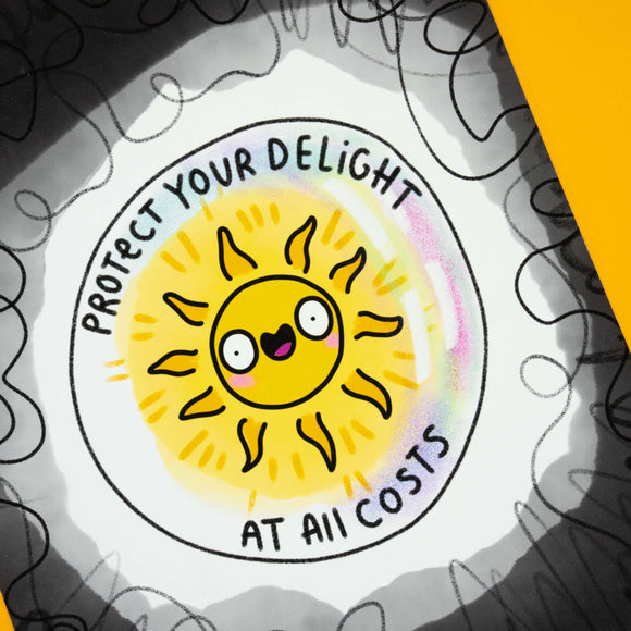 Close-up of Katie Abey’s A4 “Protect Your Delight At All Costs” art print. A cheerful sunshine character beams from the centre with bold black text. Printed on matte finish foam-backed board, signed and numbered by the artist. A quirky limited edition wall print to spark joy, positivity and colour in your home.