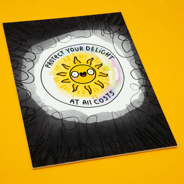 Katie Abey A4 art print featuring a bold design with a cute yellow sunshine illustration and the uplifting words “Protect Your Delight At All Costs”. The print has a matte finish, is mounted on foam-backed board, signed and numbered. Limited edition of 10, perfect for brightening your home décor or as a quirky gift.