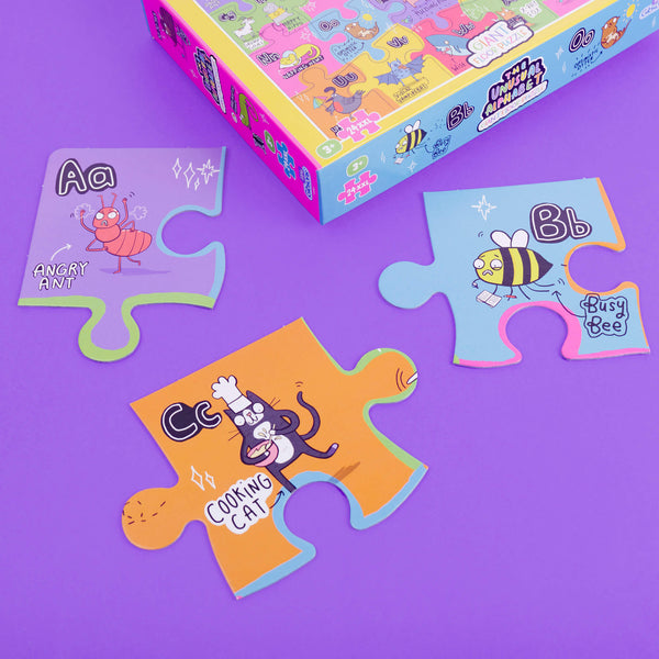 The unusual alphabet giant floor puzzle box by Katie Abey with fun characters on a purple background
