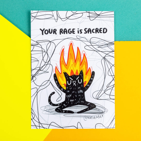 A postcard of a black cat on fire on a white background with back squiggles it has text above saying Your rage is sacred. Illustrated by Katie Abey