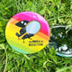 a circular shaped rainbow coloured pocket mirror with the raven of reflection on the front illustrated by Katie Abey
