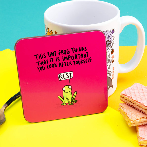 the tiny frog of rest is a cute illustration by Katie Abey on a pink base coaster with text saying This tiny frog thinks that it is important you look after yourself with a speech bubble saying REST