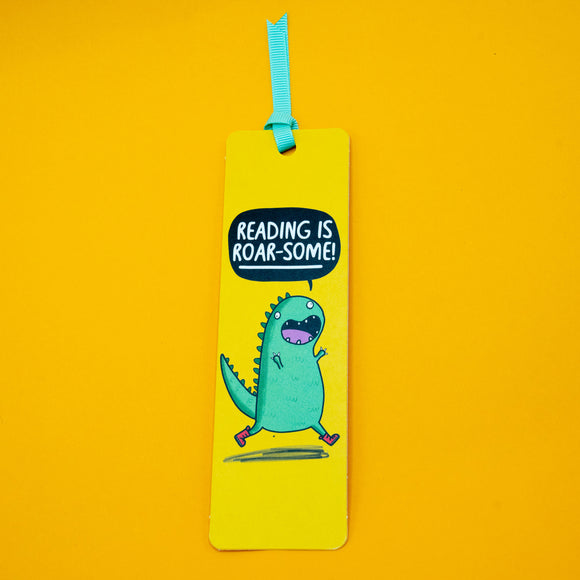 Full length Reading is Roar Some Dinosaur Bookmark by Katie Abey with green dinosaur character and bold speech bubble text, bright yellow design with turquoise ribbon, fun gift for book lovers and fans of quirky illustration.